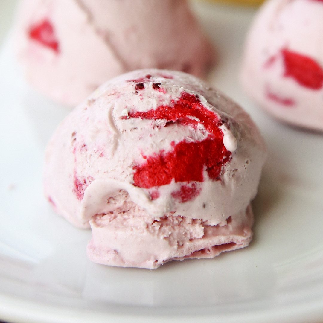 Strawberry ice cream scoops with visible red fruit pieces