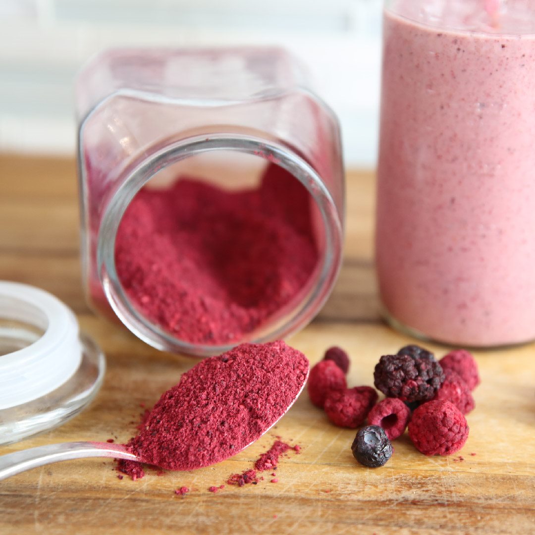 Freeze-dried berries being ground into a vivid fruit powder